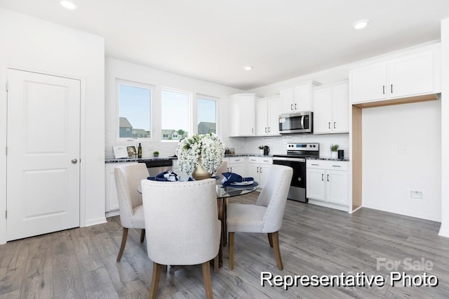 dining area with wood finished floors and recessed lighting