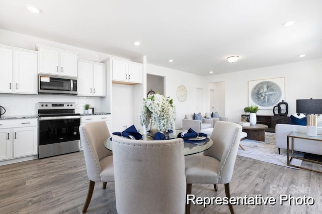 dining space featuring recessed lighting and light wood-style flooring