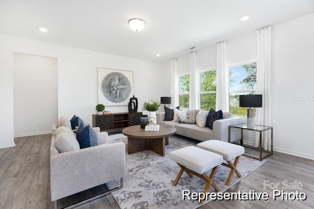 living area featuring baseboards, light wood-style flooring, and recessed lighting