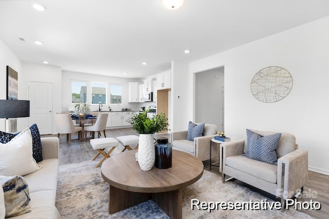 living room with light wood-type flooring and recessed lighting