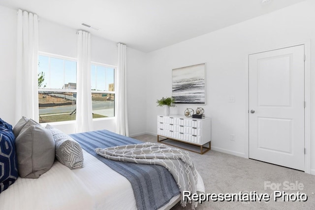 carpeted bedroom featuring visible vents and baseboards