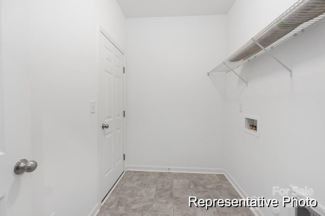 clothes washing area with laundry area, baseboards, and washer hookup