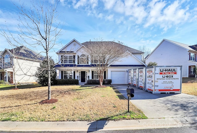 view of front facade with a garage, a front yard, and driveway