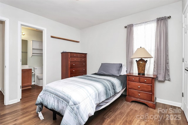 bedroom with dark wood finished floors and baseboards