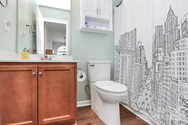 full bathroom featuring wood finished floors, vanity, and toilet