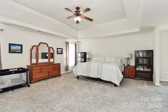 bedroom featuring carpet floors, ceiling fan, baseboards, and a raised ceiling