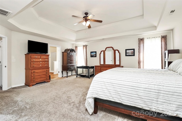 carpeted bedroom with ceiling fan, a raised ceiling, visible vents, and baseboards