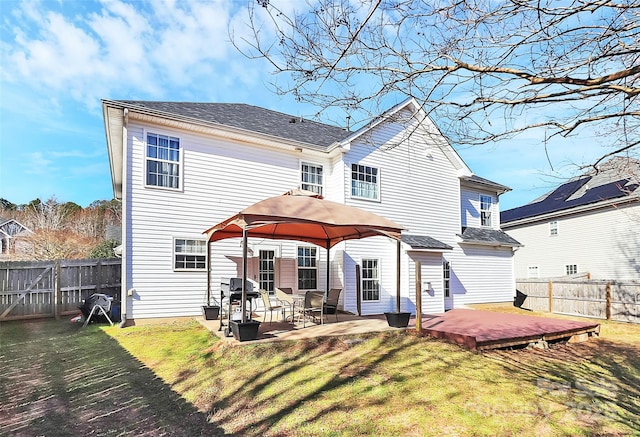 rear view of house featuring a fenced backyard, a lawn, a gazebo, and a patio