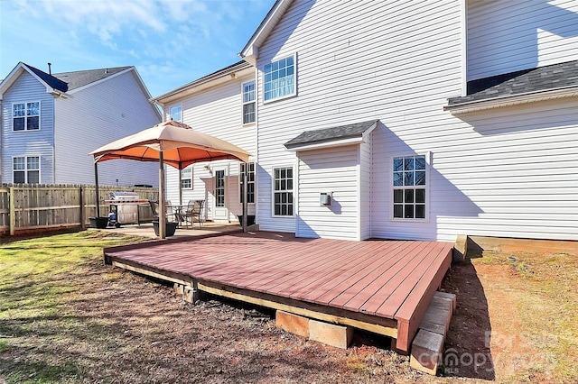 rear view of property with a gazebo, a wooden deck, and fence