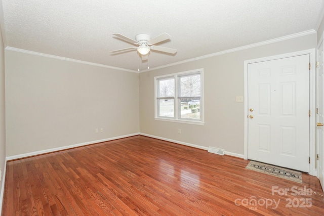 interior space featuring crown molding, a textured ceiling, visible vents, and wood finished floors