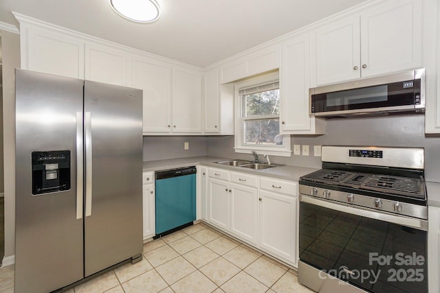 kitchen with light countertops, stainless steel appliances, white cabinetry, a sink, and light tile patterned flooring