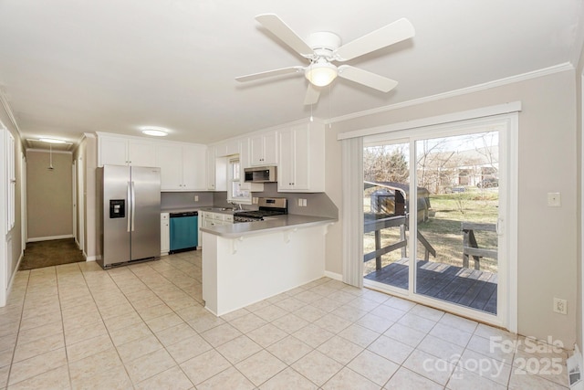 kitchen featuring light tile patterned floors, stainless steel appliances, a peninsula, white cabinets, and crown molding