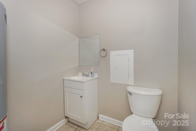 bathroom featuring toilet, vanity, tile patterned flooring, electric panel, and baseboards