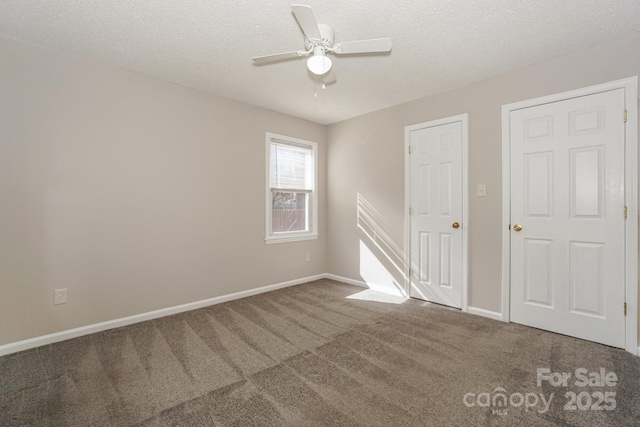 unfurnished room with a ceiling fan, carpet, a textured ceiling, and baseboards