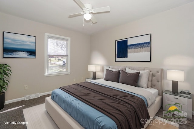 carpeted bedroom with a ceiling fan, visible vents, and baseboards