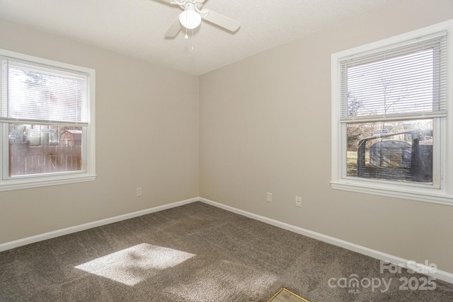 carpeted empty room featuring a ceiling fan and baseboards