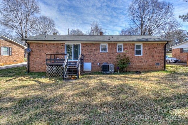 rear view of house featuring a yard, brick siding, cooling unit, and a wooden deck