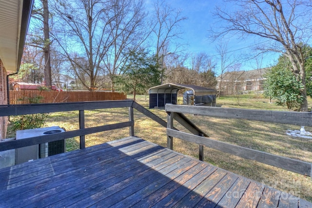 deck with fence and a detached carport