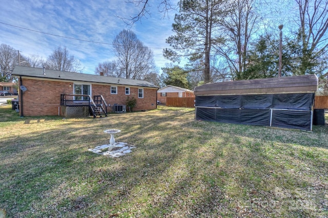 view of yard featuring fence and central AC