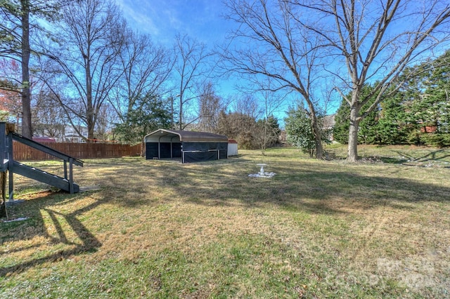 view of yard with a carport and fence