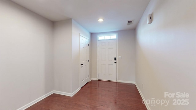 doorway to outside featuring dark wood-style floors, visible vents, and baseboards