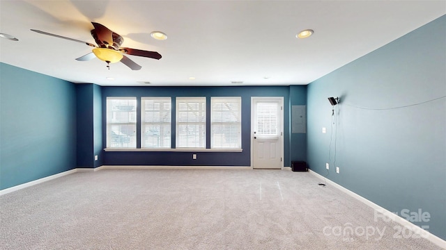 empty room featuring light colored carpet, ceiling fan, and baseboards