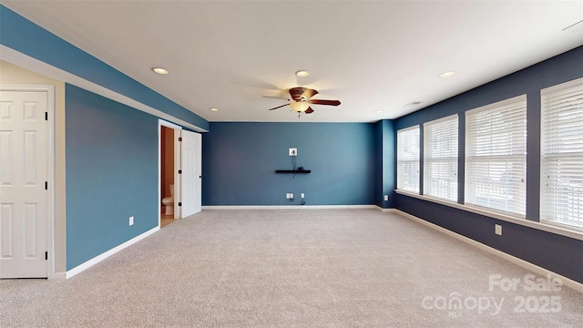 spare room featuring a ceiling fan, recessed lighting, light carpet, and baseboards