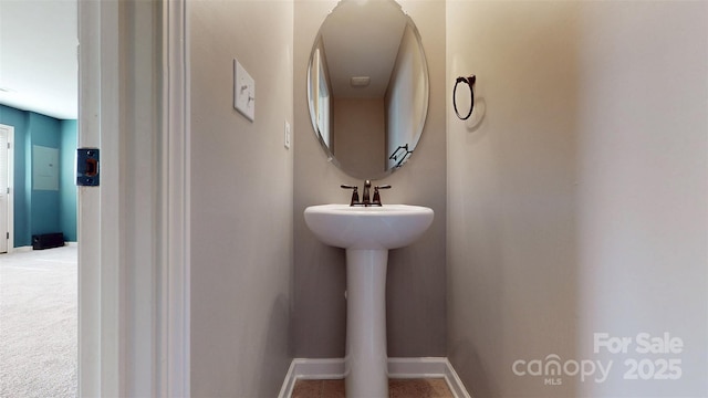 bathroom with a sink and baseboards