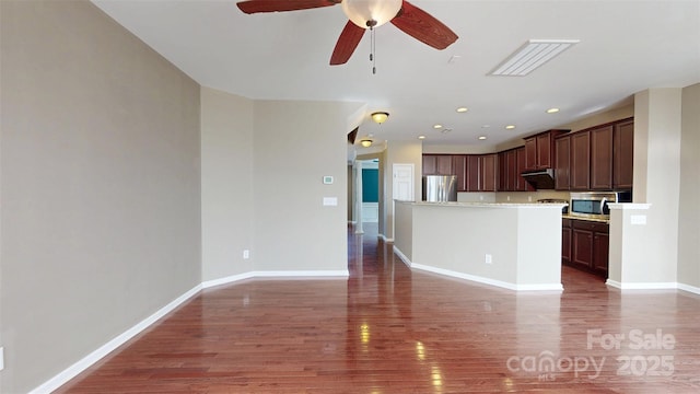 kitchen with baseboards, stainless steel appliances, dark wood-style flooring, and open floor plan