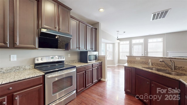 kitchen with light stone countertops, visible vents, stainless steel appliances, and a sink