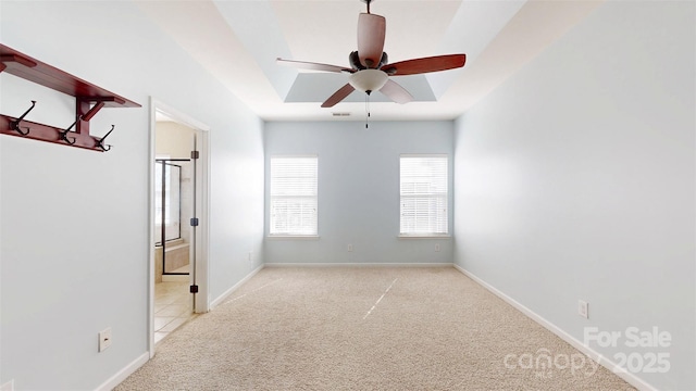 unfurnished room with baseboards, visible vents, a ceiling fan, and light colored carpet