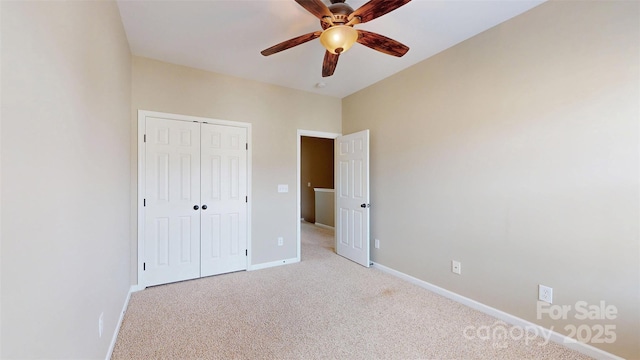 unfurnished bedroom with ceiling fan, baseboards, a closet, and light colored carpet