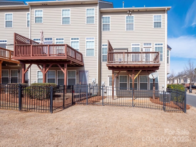 rear view of property with fence and a wooden deck