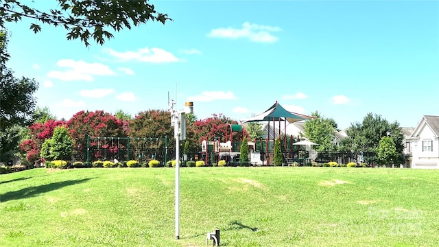 exterior space featuring a yard, playground community, and fence