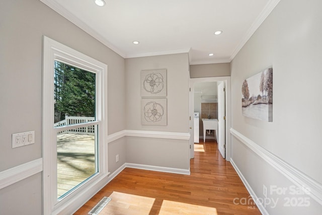 hall featuring recessed lighting, visible vents, baseboards, light wood-type flooring, and crown molding