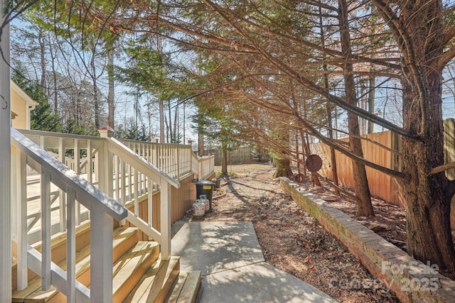 view of yard with stairs, a deck, and fence