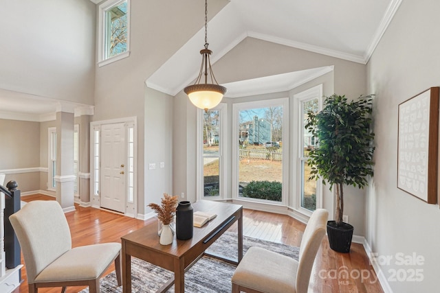 living room with crown molding, high vaulted ceiling, wood finished floors, and baseboards