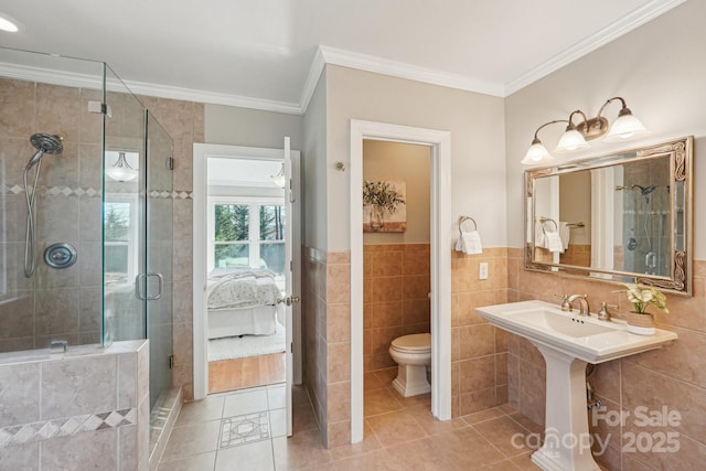 full bathroom featuring tile patterned flooring, toilet, tile walls, ornamental molding, and ensuite bath