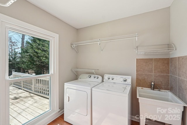 clothes washing area featuring a sink, laundry area, and washer and dryer