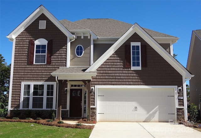 view of front of house with a shingled roof, driveway, and a garage