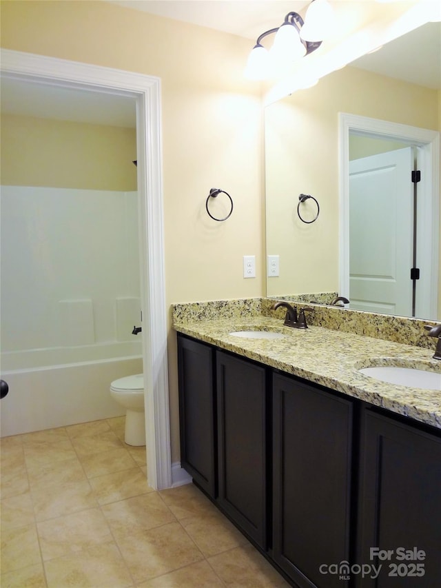 bathroom featuring tile patterned flooring, a sink, toilet, and double vanity