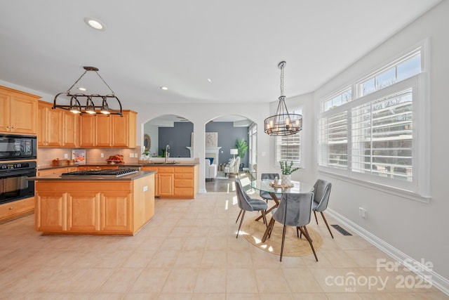 kitchen with arched walkways, recessed lighting, a sink, black appliances, and baseboards