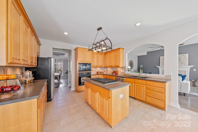 kitchen with decorative backsplash, dark countertops, a sink, and black appliances