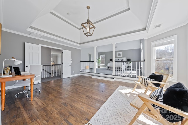 interior space featuring a healthy amount of sunlight, crown molding, a tray ceiling, and wood finished floors