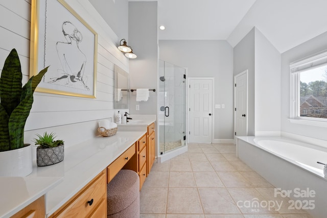 bathroom featuring lofted ceiling, tile patterned floors, a garden tub, vanity, and a shower stall