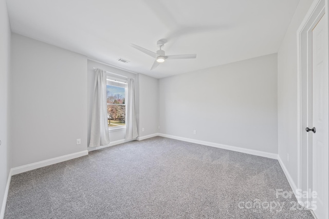 carpeted empty room featuring ceiling fan, visible vents, and baseboards