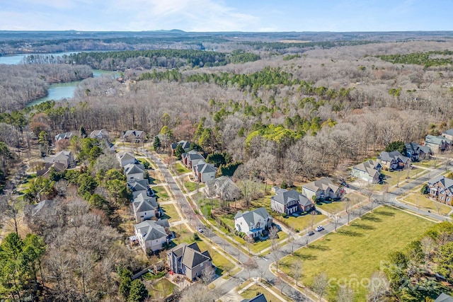 birds eye view of property featuring a water view, a wooded view, and a residential view