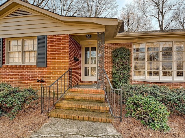 view of exterior entry with brick siding