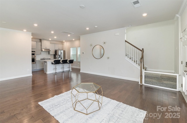 living room featuring dark wood-style floors, stairs, visible vents, and crown molding