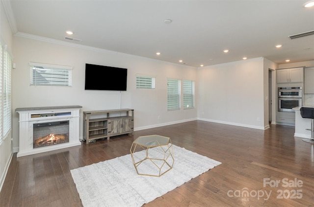 living room with crown molding, visible vents, and wood finished floors